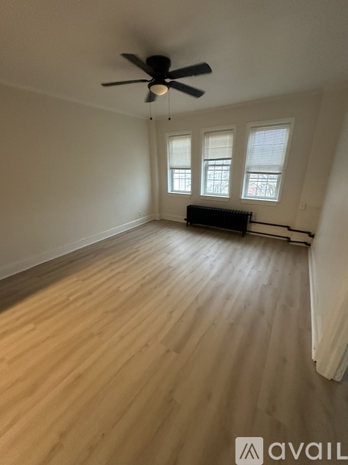 A room with a ceiling fan and wooden flooring.
