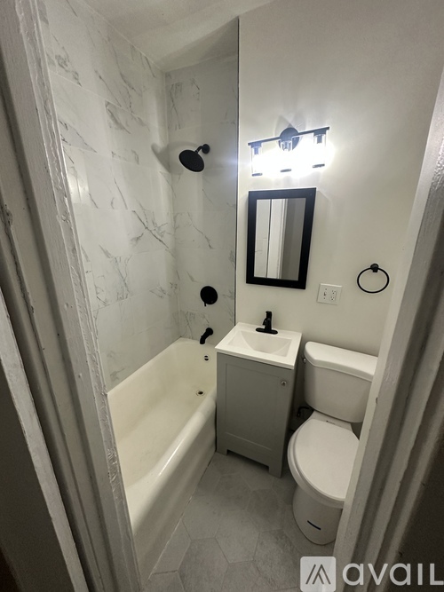 A bathroom with a tub, toilet and sink.