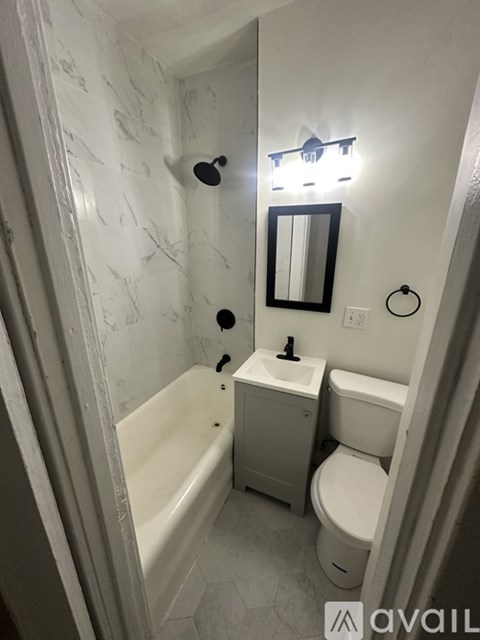 A bathroom with a tub, toilet and sink.