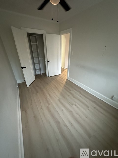 A room with wooden flooring and a ceiling fan.