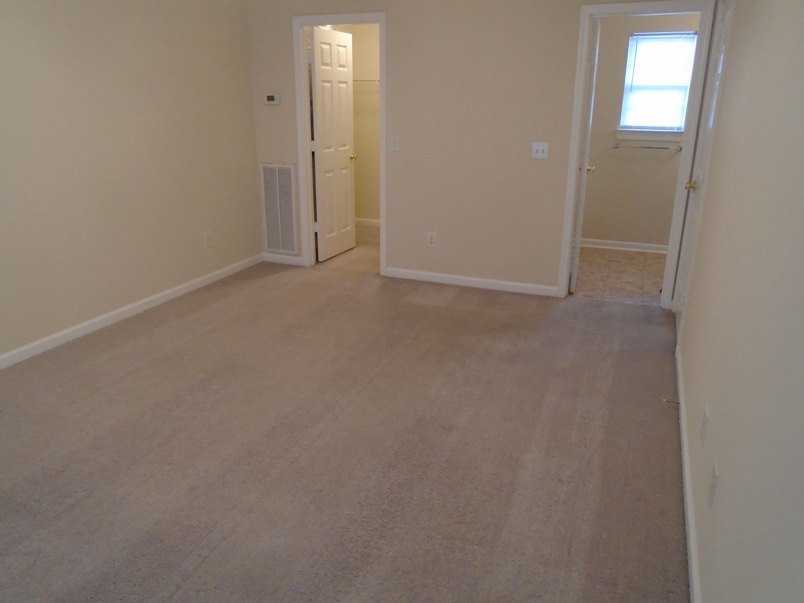 an empty living room with a wooden floor and a white door
