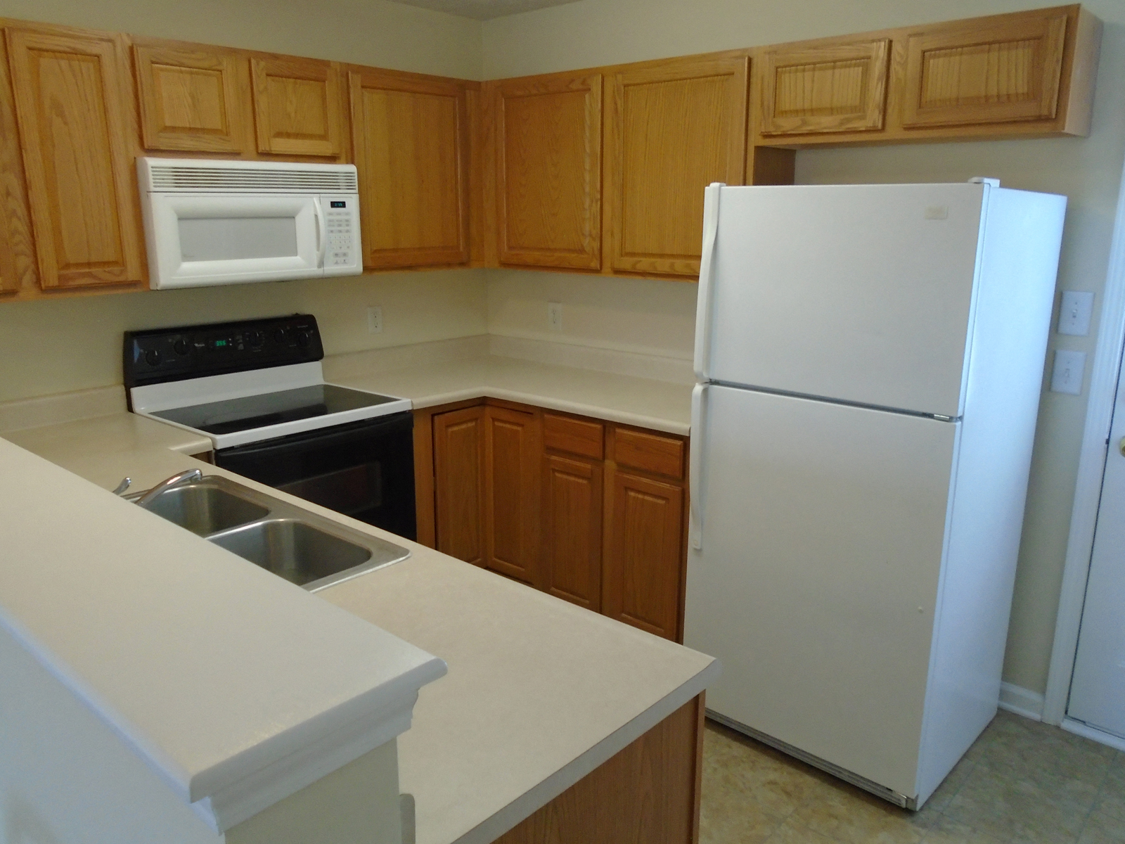 a kitchen with white appliances and wooden cabinets