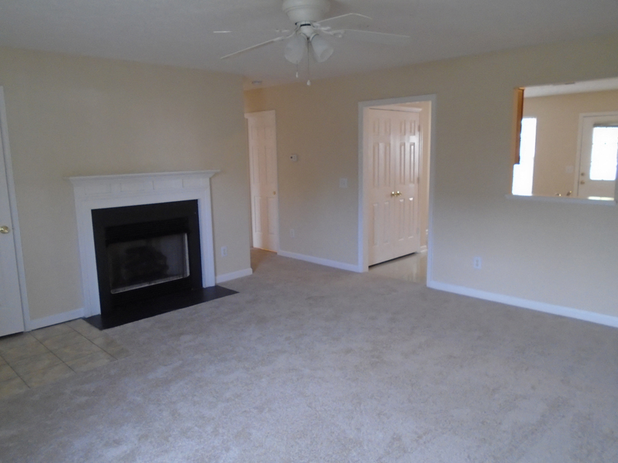 an empty living room with a fireplace
