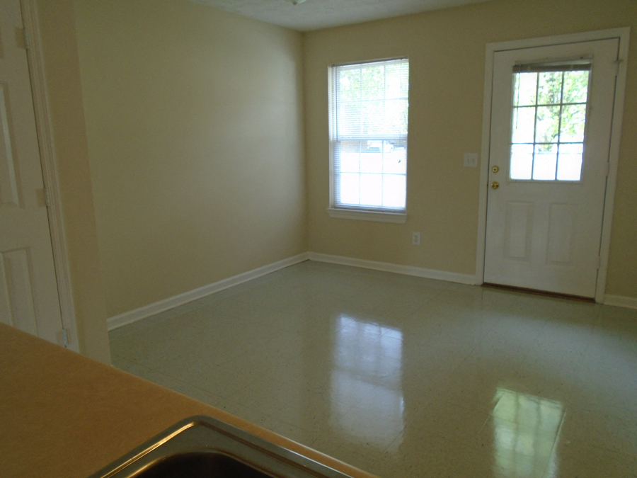 an empty living room with a sink and a door
