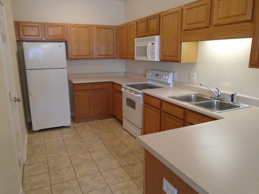 a kitchen with white appliances and wooden cabinets