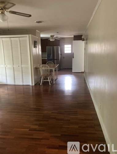 A room with wooden floors and a ceiling fan.