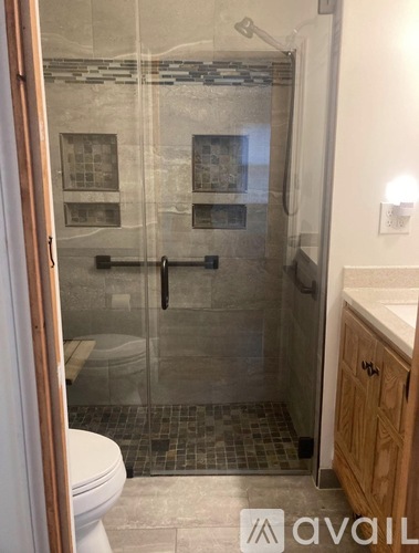 A bathroom with a glass shower door and a white toilet.