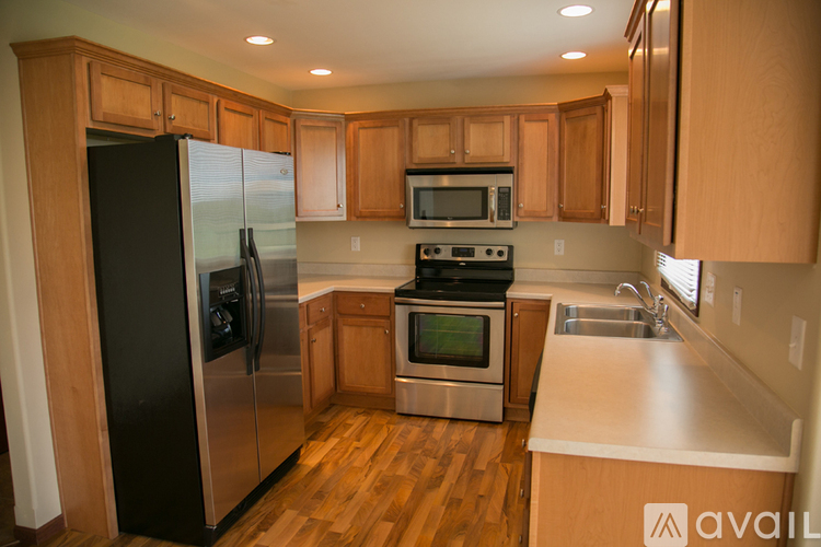 A kitchen with wooden cabinets and a black refrigerator.
