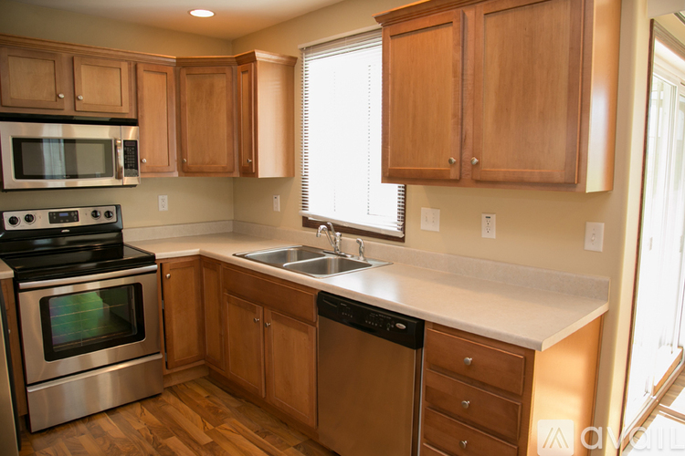A kitchen with wooden cabinets and a stainless steel oven.