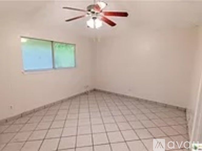 A room with a ceiling fan and a window.