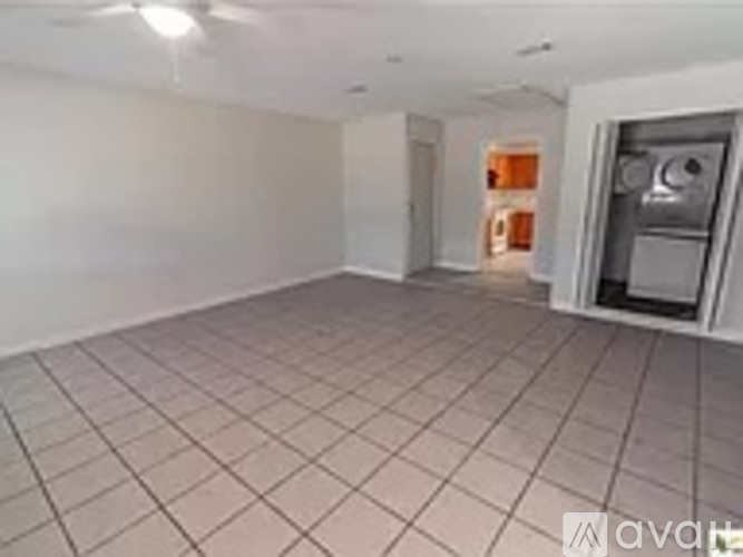 A spacious room with a tiled floor and a ceiling fan.
