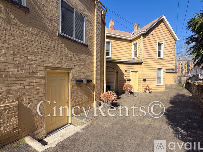 A yellow door is on the left side of a brick building.