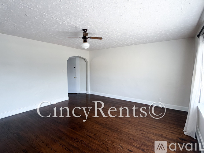 A room with a ceiling fan and wooden flooring.