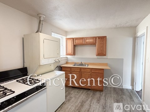 A kitchen with a white stove and wooden cabinets.