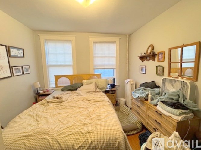 A bedroom with a bed and a wooden dresser.