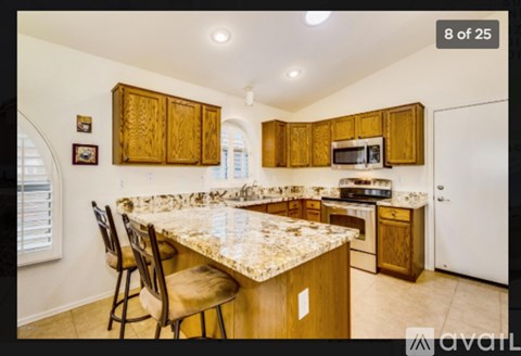 A kitchen with wooden cabinets and a granite countertop.