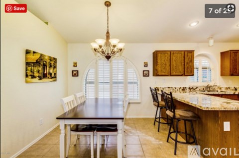A dining room with a large table and chairs.