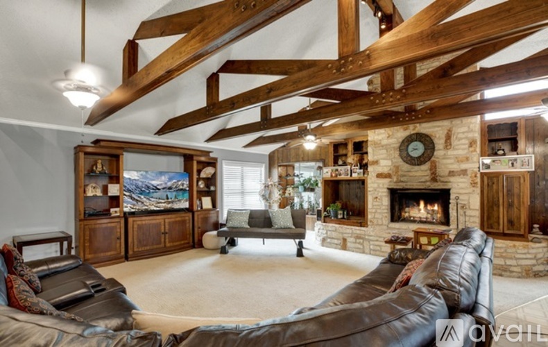 A living room with a leather couch and a fireplace.