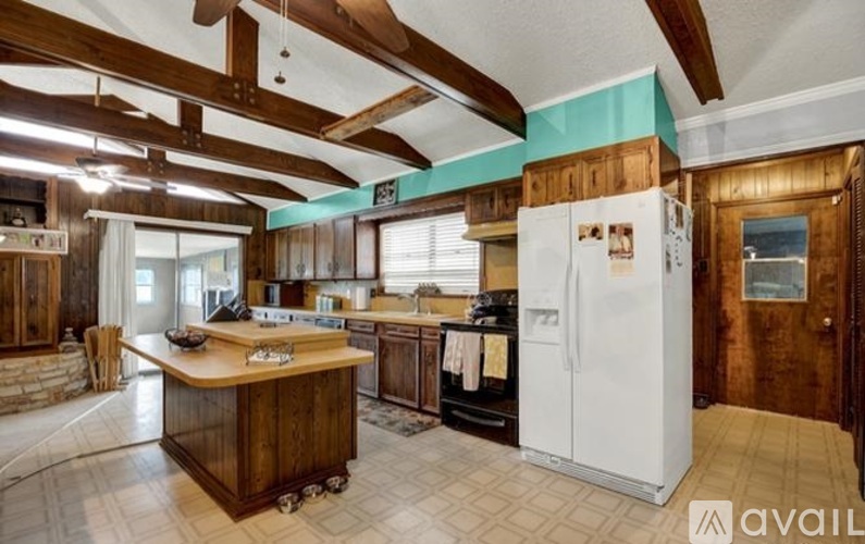 A kitchen with wooden cabinets and a white refrigerator.