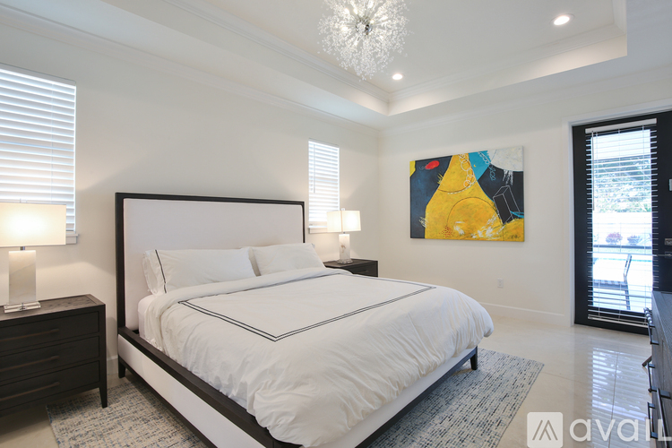 A bedroom with a large bed and a painting on the wall.