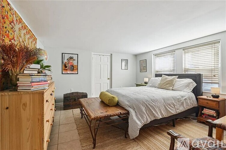 A bedroom with a bed, a dresser, and a chair.