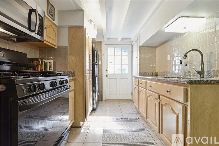 A kitchen with a black stove top oven and a black microwave above it.