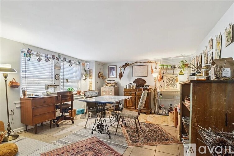 A room with a desk, chairs, and a rug.
