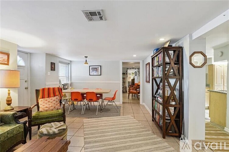 A living room with a sofa, chairs, and a bookshelf.