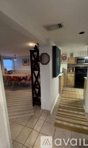 A living room with a dining table and chairs is visible through a doorway.