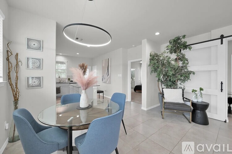 A modern dining room with a glass table and blue chairs.