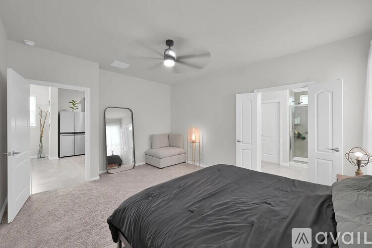 A bedroom with a large bed and a ceiling fan.