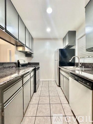A kitchen with black appliances and white cabinets.