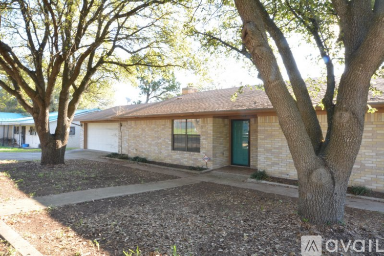 A house with a green door is surrounded by trees.