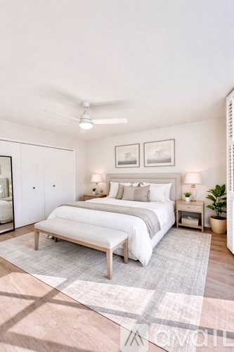 A bedroom with a large bed and a ceiling fan.