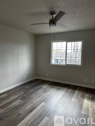 A room with a ceiling fan and a window.