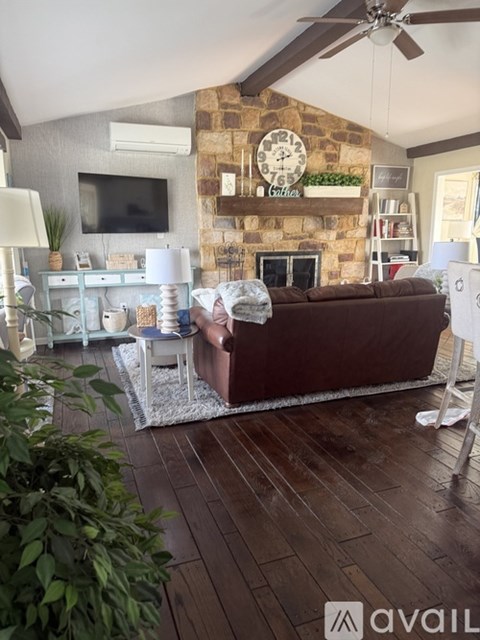 A living room with a brown couch and a fireplace.