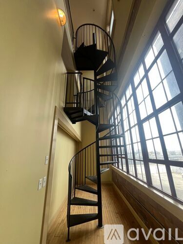 A spiral staircase in a room with large windows.