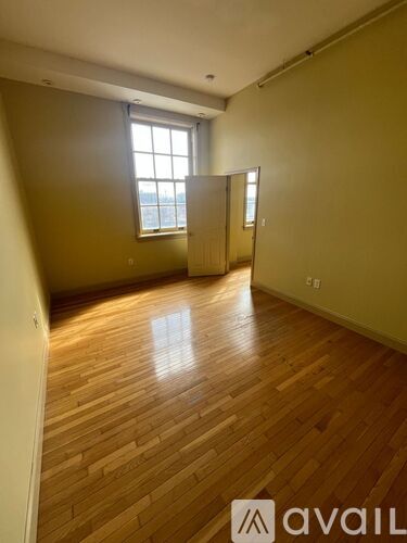 A room with wooden flooring and a window.