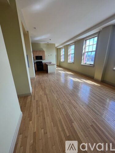 A room with wooden flooring and a large window.
