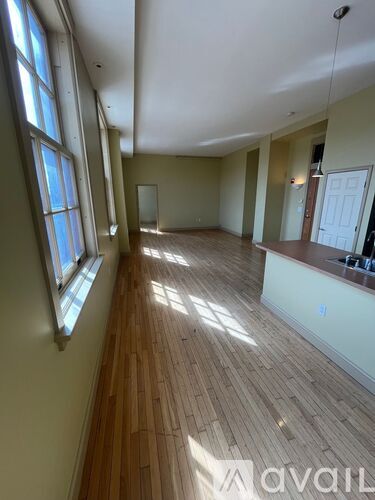 A room with wooden floors and large windows.