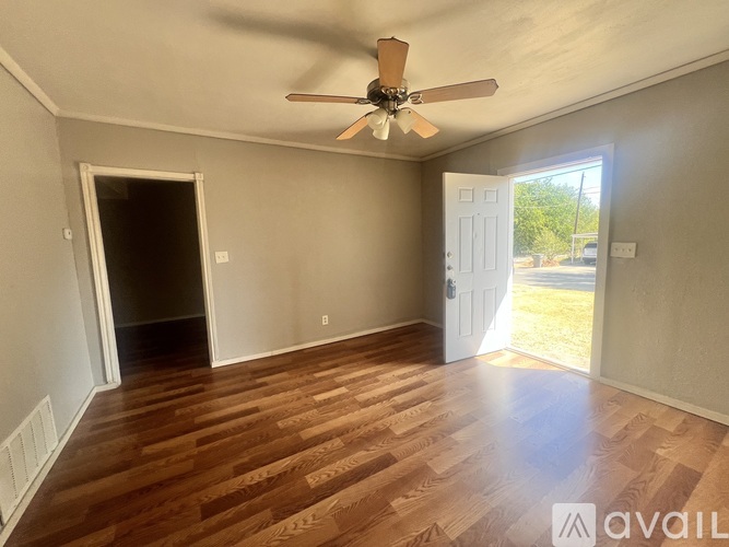 A room with wooden flooring and a ceiling fan.