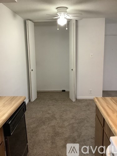 A room with a carpet floor and a wooden counter top.