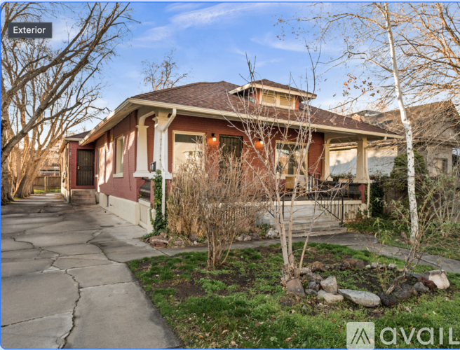 A house with a red brick exterior and a white trim is for sale.