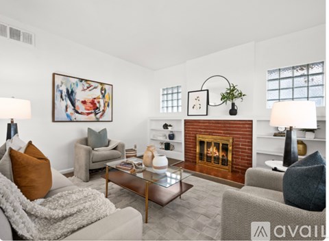 A living room with a fireplace and a painting on the wall.
