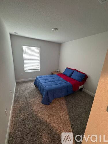 A bedroom with a bed and a window.