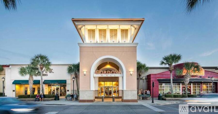 A storefront with a large entrance and palm trees in the background.