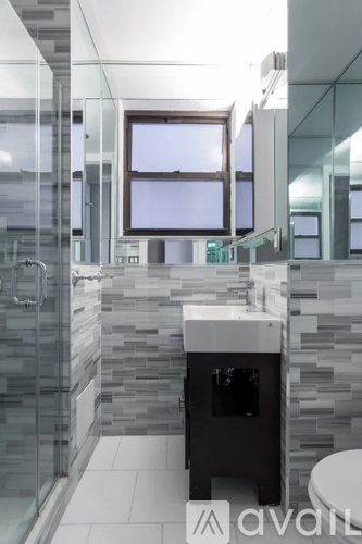 A modern bathroom with a glass shower stall and a sink.