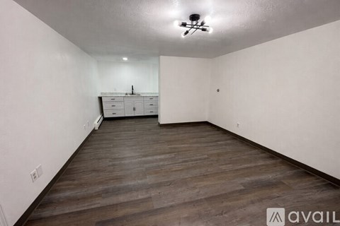 A room with wooden flooring and a white ceiling with a light fixture.