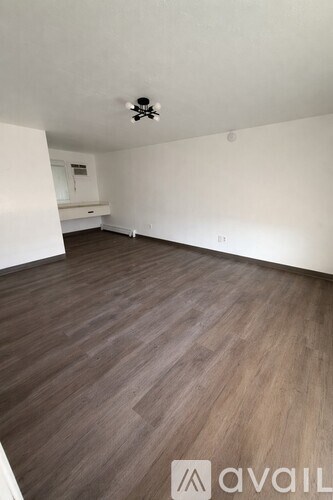 A room with wooden flooring and a ceiling fan.