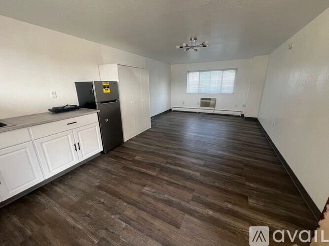 A kitchen with white cabinets and a black fridge.
